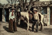 Két cowboy élvezi a pihenőidőt egy marhafarmon a texasi Bandera Hillsben, 1928-ban