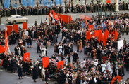 Táncoló emberek és észak-koreai zászlók egy moszkvai felvonuláson