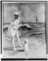 Fiatal nő fürdőruhában egy kiskutyával egy forgatáson (1913)