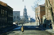 Egy kislány sétál egy macskaköves utcán, nem messze a Moszkva folyó mellett