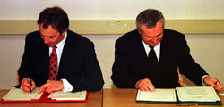 Tony Blair brit és Bertie Ahern ír miniszterelnökök aláírják az egyezményt