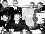 Joachim von Ribbentrop (b2) és Vjacseszlav Molotov (ü.) aláírják a megnemtámadási szerződést Borisz Saposnyikov marsall (b) és Joszif Sztálin (b3) társaságában Moszkvában, 1939. augusztus 23-án.