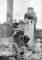 Egy asszony a gyermekeivel a romokon