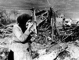 Idős asszony porig rombolt háza előtt sírdogál Leningrádban