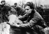 Orosz nővér segít egy fejsérüléses katonának a harcmezőn