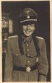 Egy francia leány egy Untersturmführer tiszti egyenruhában. Az SS harci alakulatai nem vettek fel nőket tagjaik közé, így minden bizonnyal tréfából öltötte magára az uniformist, amely valószínűleg a szeretőjéé lehetett (a kép készítési helye ismeretlen)