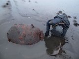 Tűzszerész vizsgál egy iszapba ragadt brit tengeri aknát Izland keleti partján 2016 januárjában (kép forrása: icelandmag.is)