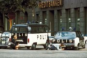 Autóik mögött fedezékbe bújt rendőrök a bank előtt (kép forrása: alltomhistoria.se)