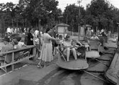 Gyerekek élvezik a kanyargó nevű játékot a kis vidámparkban (1948)