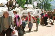 Menekültek vonulnak el az ENSZ lövészpáncélosai mellett Potočarinál 1995. július 13-án (kép forrása: spiegel.de)