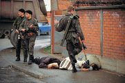 Szerb félkatonai csoport tagja rúg egy meglőtt muszlim nőbe 1992-ben (kép forrása: time.com)