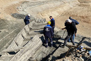 A régészcsapat tagjai és a bányavállalat munkatársai a megkárosodott nagyobb hajóroncsot vizsgálják (kép forrása: All That's Interesting / Institute of Archaeology)