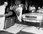 A 66-os Mustang előkészítése a „sebészeti műveletre”, amelynek segítségével a 86. emeletre röpítették a kabriót. A „sebészek” éppen a főkonzolt és az üléseket szerelik ki az autóból. Az ultrasteril hatású műanyag hablapokon a Mustang egyéb alkatrészei fekszenek.