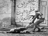 Iráni katona fedezékbe húzza sérült társát a Horramsahr városáért folytatott harcok alatt,1980.