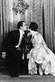Mary Brian, 1929 – Buddy Rogers és Mary Brian színészek csókolóznak a fagyöngy alatt. A színésznő műselyemből készült, csókanyakú nagyestélyit visel, ünnepi hangulatú szaténdíszítésekkel.