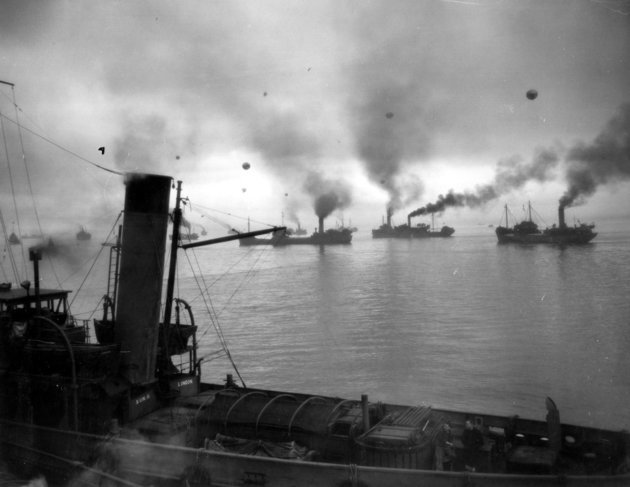 Hajnalban útnak induló szövetséges konvoj kísérőhajókkal és a légitámadások ellen védő, dróttal rögzített ballonokkal