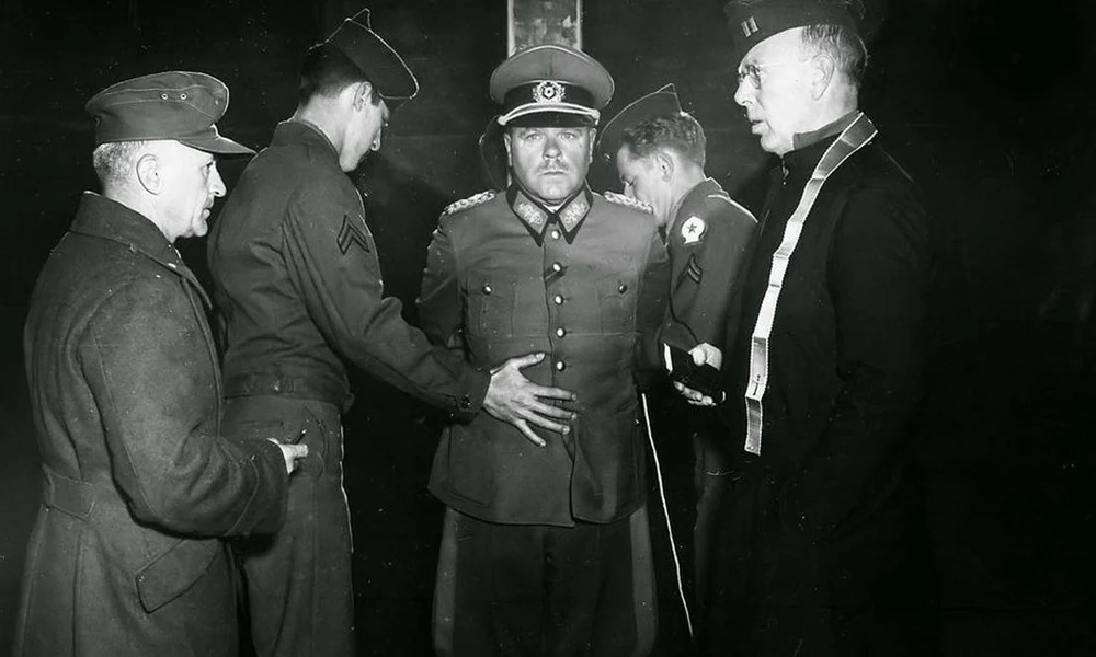 Anton Dostlert, a Wehrmacht tábornokát megkötözik kivégzése előtt 1945. december 1-jén. Azért ítélték halálra, mert az olaszországi La Speziában 15 fegyvertelen amerikai hadifogoly lelövetését rendelte el.