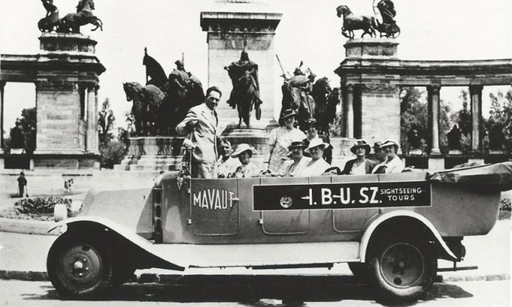 Az IBUSZ 1925-ben indította el a fővárosban autóbuszos városnéző szolgáltatását. A korszerű, nyitott társasgépkocsik körútjuk során természetesen a Városligetet is útba ejtették. Az 1930-as években készült felvételen városnéző k