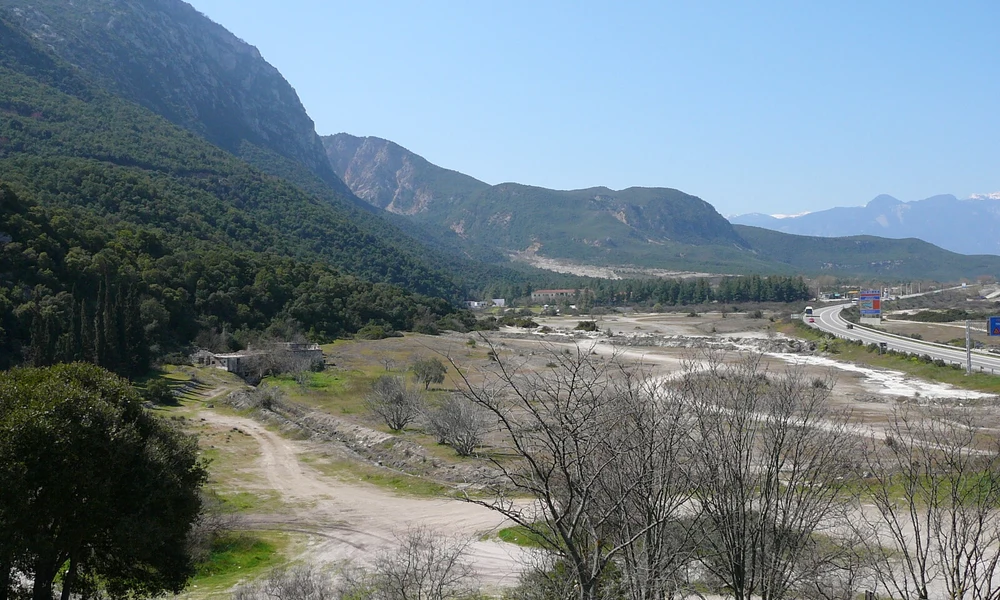 A Thermopülai a fókiai fal környékéről nézve. Az ősi partvidék közelebb volt a hegyhez, a jobb oldali út közelében. Fotó: Wikipedia/Fkerasar, CC BY-SA 3.0