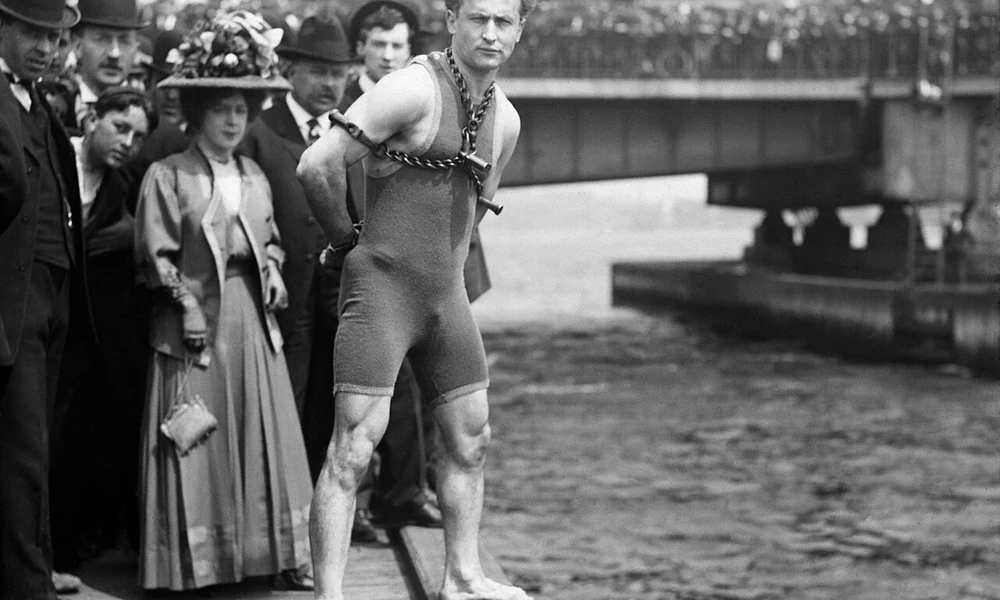Harry Houdini egy 1908-as bostoni mutatványa előtt, láncokkal és bilincsekkel a testén