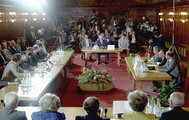 A politikai egyeztető tárgyalás résztvevői a Parlament Vadásztermében 1989 nyarán. A jobb oldali asztalnál az MSZMP képviselői, szemben Szűrös Mátyás, az Országgyűlés elnöke, bal oldalon pedig az Ellenzéki Kerekasztal képviselői foglaltak helyet.