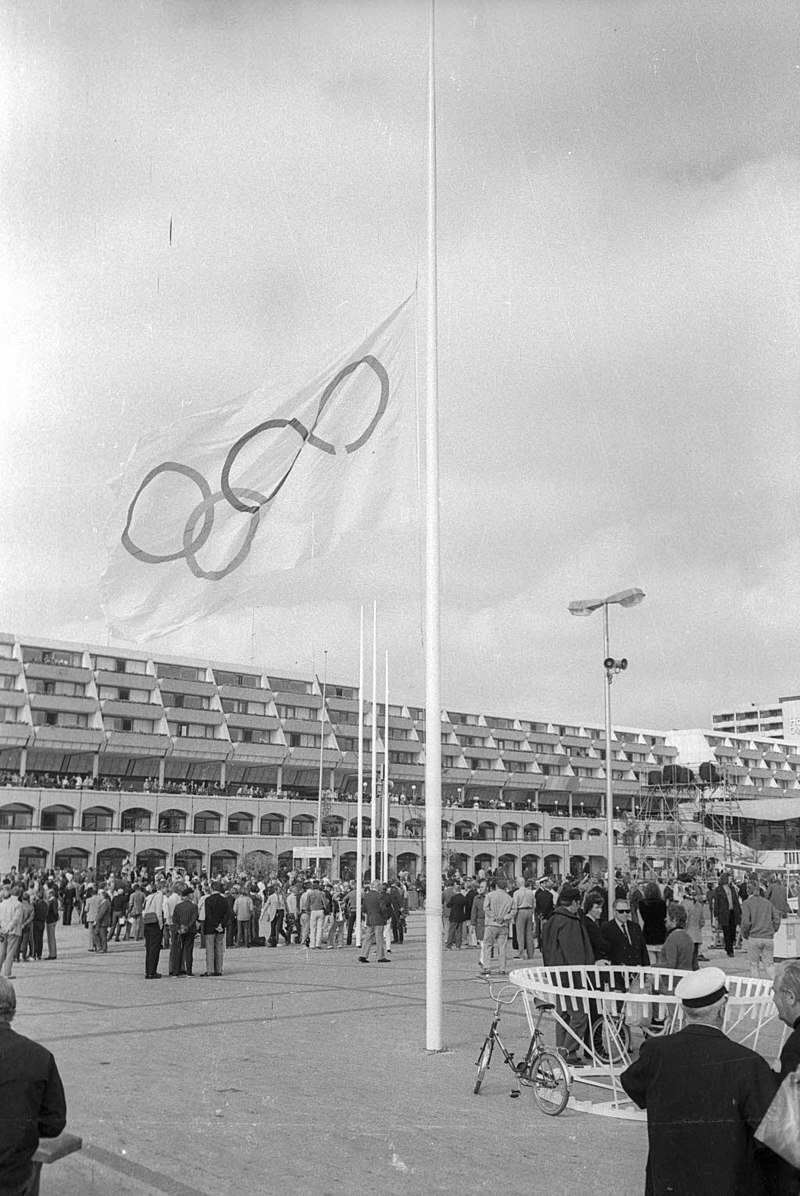 Az olimpiai zászló az Olimpiai Központ előtt félárbocra eresztve lobog (forrás: wikipédia / Magnussen, Friedrich (1914-1987) - Stadtarchiv Kiel / CC BY-SA 3.0 de)